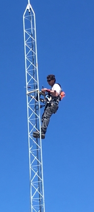 A man on a tall radio tower