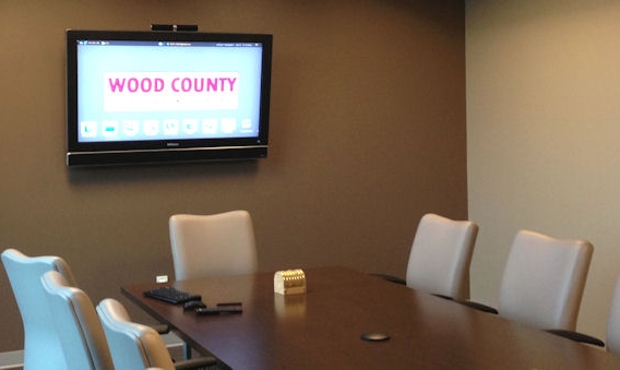 A conference room in Wood County with a long table and wall mounted display